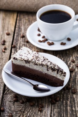 Çikolata tatlı kahve fincanı ve kahve çekirdekleri ahşap bac üzerinde