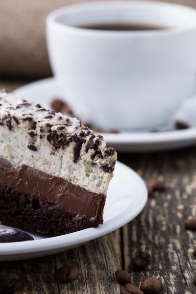 Dessert al cioccolato con tazza di caffè e chicchi di caffè su bac di legno — Foto Stock