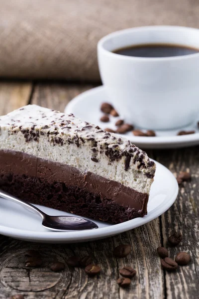 Schokoladendessert mit Kaffeetasse und Kaffeebohnen auf Holzbacken — Stockfoto