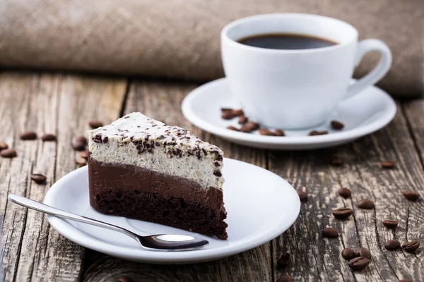 Schokoladendessert mit Kaffeetasse und Kaffeebohnen auf Holzbacken — Stockfoto