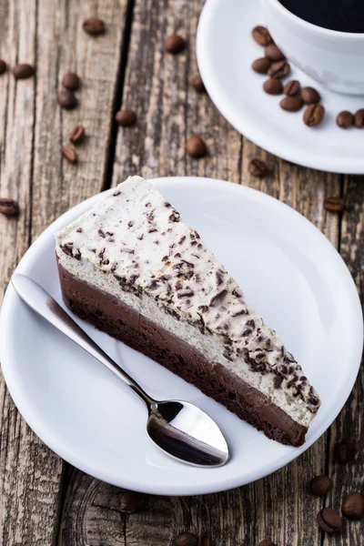 Dessert al cioccolato con tazza di caffè e chicchi di caffè su bac di legno — Foto Stock