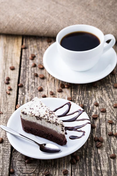 Schokoladendessert mit Kaffeetasse und Kaffeebohnen auf Holzbacken — Stockfoto