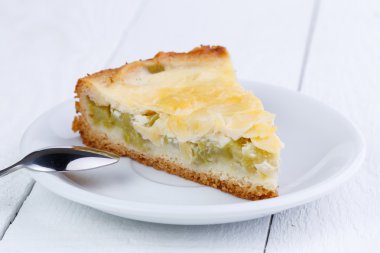 Ahşap masa üzerinde ravent pastadan dilim.