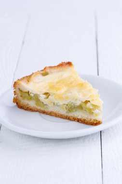 Ahşap masa üzerinde ravent pastadan dilim.