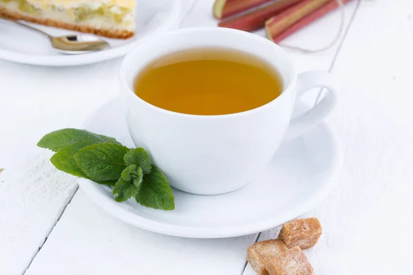 Herbata miętowa z kawałek ciasto z rabarbarem na drewnianym stole. — Zdjęcie stockowe