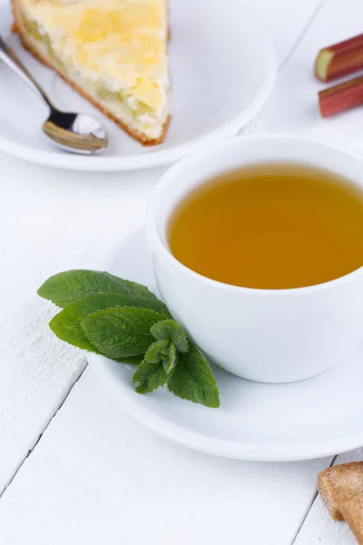 Mint tea with slice of rhubarb pie on wooden table. — Stock Photo, Image