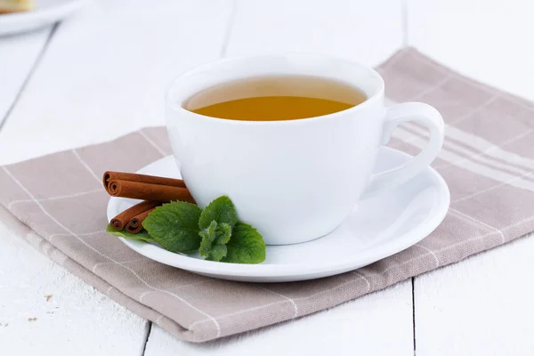 Mint tea with cinnamon on wooden table. — Stock Photo, Image