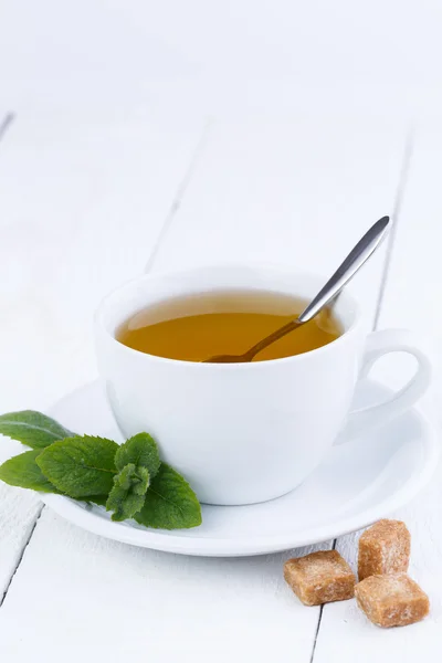 Mint tea with brown sugar on wooden table. — Stock Photo, Image