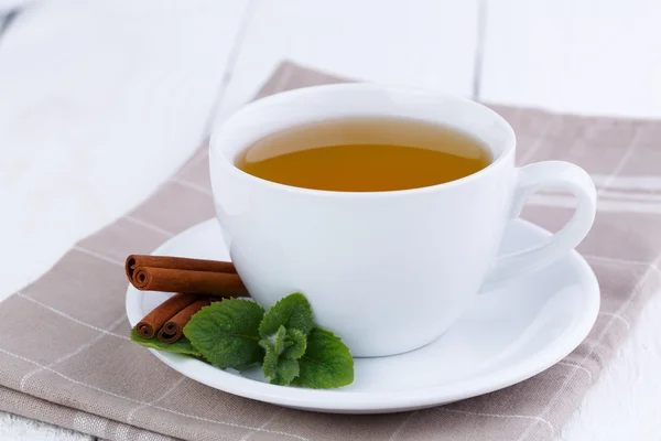 Mint tea with cinnamon on wooden table. — Stock Photo, Image