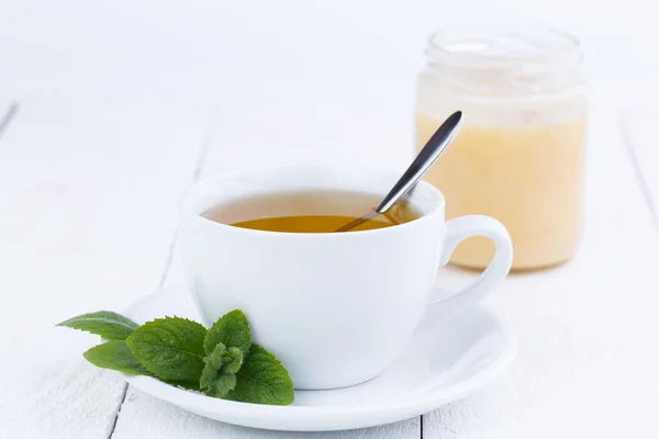 Mint thee met honing op houten tafel. — Stockfoto