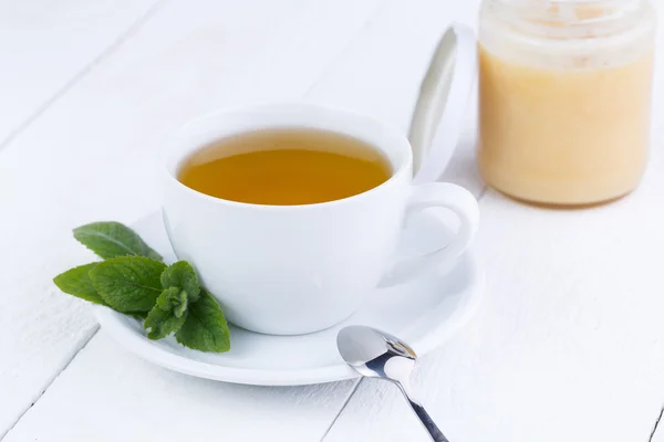 Miętową herbatę z miodem na drewnianym stole. — Zdjęcie stockowe