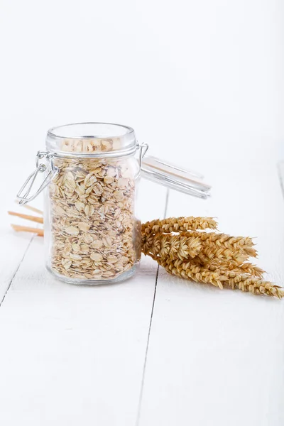 Los copos de avena en frasco de vidrio y trigo . —  Fotos de Stock