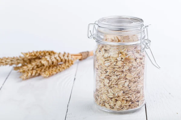 Haferflocken im Glas und Weizen. — Stockfoto