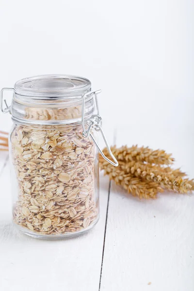 Los copos de avena en frasco de vidrio y trigo . —  Fotos de Stock