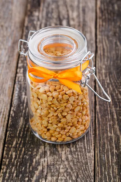 Gedroogde erwten in een glazen pot op houten tafel. — Stockfoto