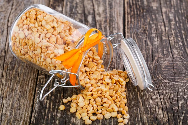 Gedroogde erwten in een glazen pot op houten tafel. — Stockfoto