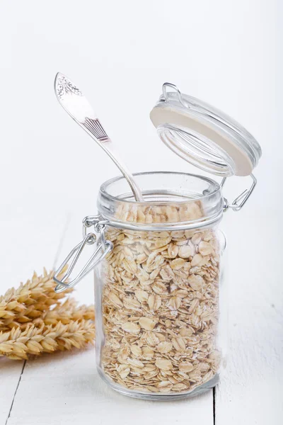 The oat flakes in opened glass jar with spoon. — Stock Photo, Image