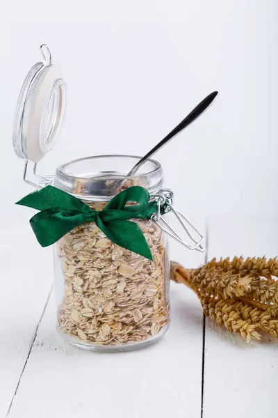 Los copos de avena en frasco de vidrio y cinta verde . —  Fotos de Stock