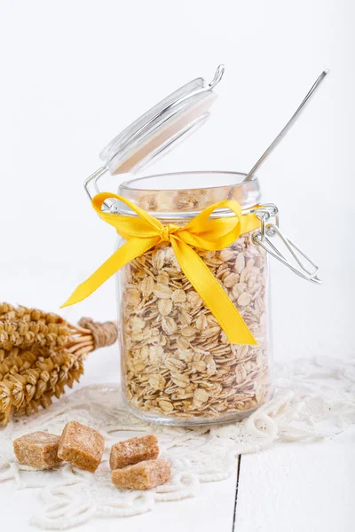 The oat flakes in glass jar and wheat. — Stock Photo, Image