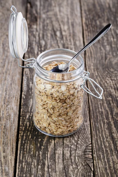 The oat flakes in jar on wooden table. — Stock Photo, Image
