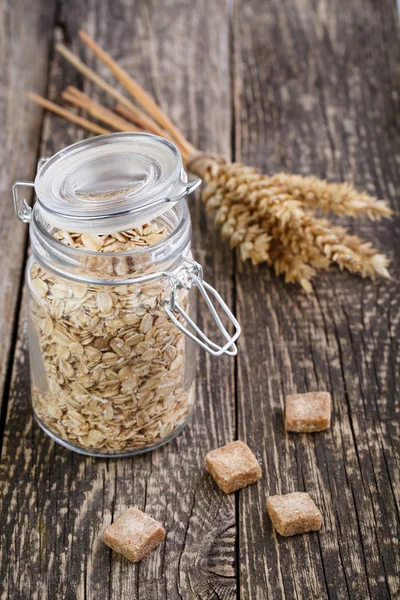 I fiocchi d'avena in vaso con zucchero di canna e cucchiaio . — Foto Stock