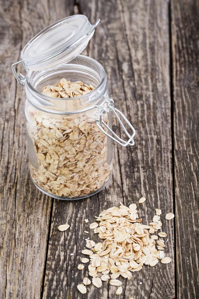 Copos de avena derramados del frasco . — Foto de Stock