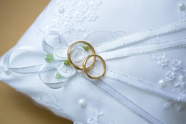 Anéis de casamento de ouro em um travesseiro . — Fotografia de Stock