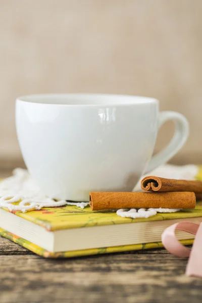 Weiße Tasse Kamillentee und Buch auf dem Tisch. — Stockfoto