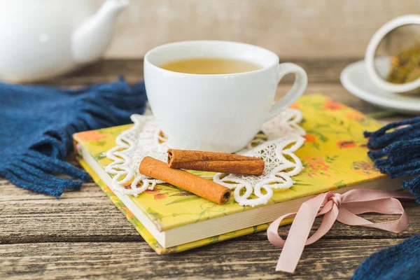 Weiße Tasse Kamillentee und Buch auf dem Tisch. — Stockfoto