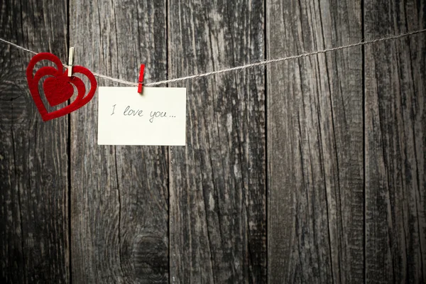 Parole scritte a mano ti amo e cuori su sfondo di legno . — Foto Stock
