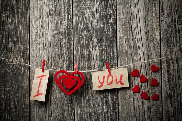Palavras escritas à mão Eu te amo e corações em fundo de madeira . — Fotografia de Stock