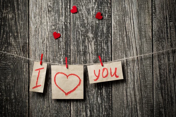 Napsaná slova miluji vás a srdce na dřevěné pozadí. — Stock fotografie