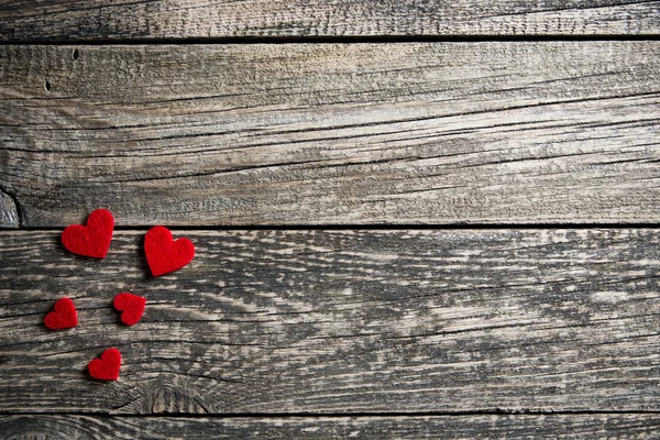 Fondo de madera marrón con corazones rojos . — Foto de Stock