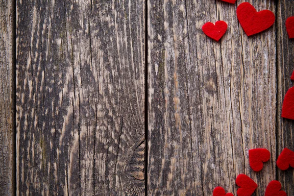 Brown wooden background with red hearts. — Stock Photo, Image