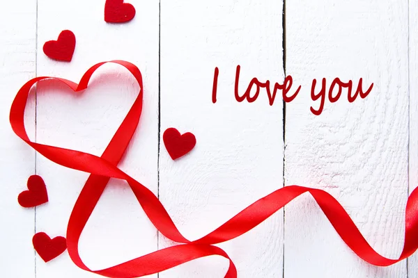 Cinta roja en forma de corazón sobre mesa blanca . — Foto de Stock