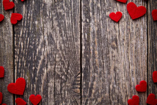 Brown wooden background with red hearts. — Stock Photo, Image