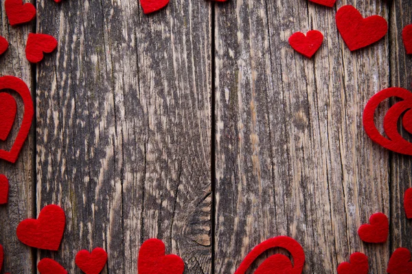 Brown wooden background with red hearts. — Stock Photo, Image