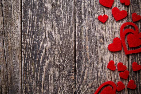 Fondo de madera marrón con corazones rojos . — Foto de Stock