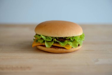 Hamburger ya da çizburger, ahşap arka planda yakın plan.