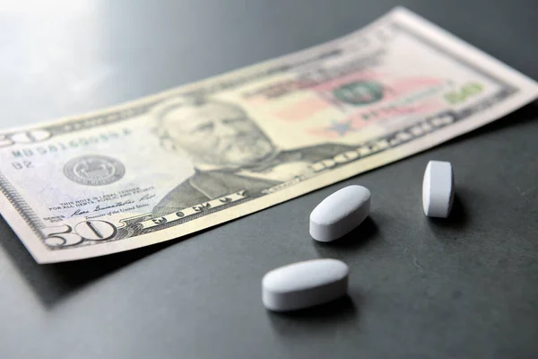 Medicine pills with money, dollar. Medical or pharmacy prescription for health. Business, finance concept.