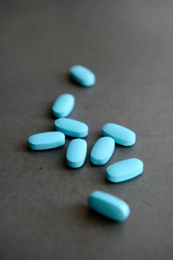 Mavi haplar. Eczacılık ilaçları karanlık arka planda.
