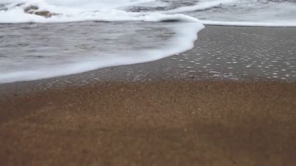 Gros plan du bord de mer mousseux à la plage — Video