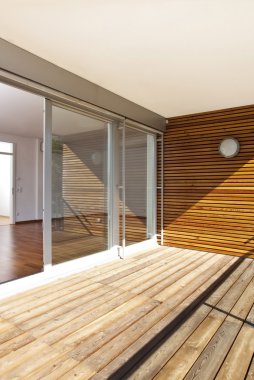Güneşli balkon ve ahşap zemin ile modern ev