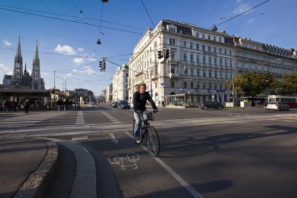 Urbanes geschehen an einer kreuzung in der stadt wien mit fahrrädern und autos — Stockfoto