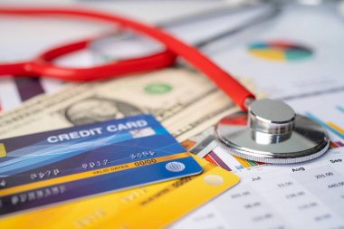 Grafik, Finans, Hesap, İstatistik, Analitik araştırma verileri ve İşletme Sağlık Toplama Konsepti üzerine ABD Doları banknotları ile steteskop ve kredi kartı