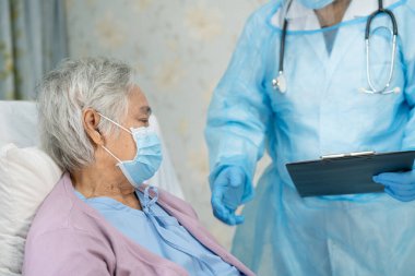 Yüz maskesi takan Asyalı bir doktor ve karantina hastanesi koğuşundaki Covid-19 Coronavirus salgınını kontrol etmek için PPE giysisi..