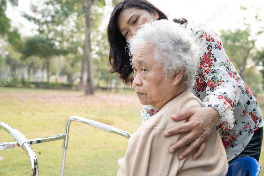 Help and care Asian senior or elderly old lady woman use walker with strong health while walking at park in happy fresh holiday.