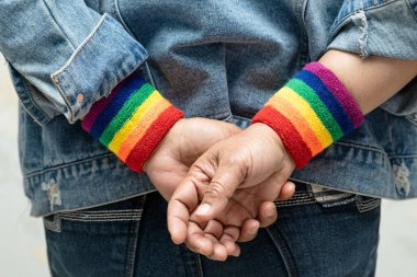 Gökkuşağı bilekliği takan Asyalı kadın, LGBT onur ayının sembolü Haziran sosyal ortamında gey, lezbiyen, biseksüel, transseksüel, insan hakları.