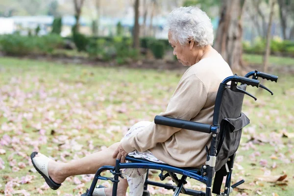 亚洲老年老年妇女病人在公园坐轮椅时膝部疼痛 健康有力的医疗理念 — 图库照片