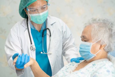 Yüz maskesi takan Asyalı bir doktor ve karantina hastanesi koğuşundaki Covid-19 Coronavirus salgınını kontrol etmek için PPE giysisi..